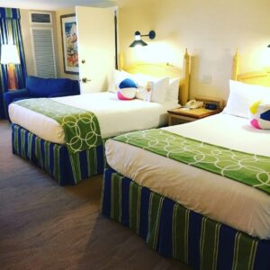 Paradise Pier two queen beds with white spread and green throw