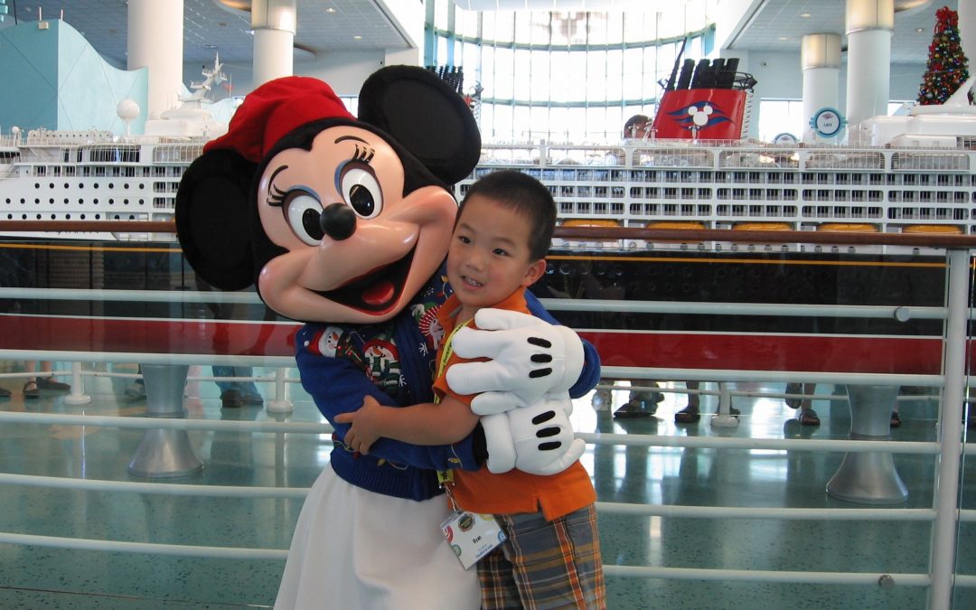 Minnie Mouse greets guests waiting to board the Disney Cruise ships